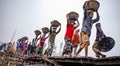 A line of Workers carrying the heavy loads of coal in baskets