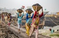 A line of Workers carrying the heavy loads of coal in baskets