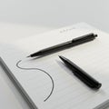 Lined notepad with a smooth, black ink pen resting on it. Royalty Free Stock Photo