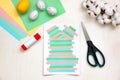 Lined strips of paper, multi-colored sheets, scissors, glue, Easter eggs on a light table. DIY concept. Step by step instructions Royalty Free Stock Photo