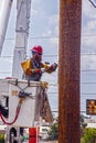 Lineman Utility worker in bucket working on electric pole hammering - helping restore power after supercell hit