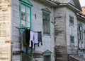 The linen is hung to dry out the window of an old wooden barrack