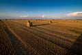 lines of stubble after harvest and hay in bales Royalty Free Stock Photo