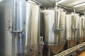 Lines of metal tanks in modern brewery. Shopfloor with brewery facilities. Manufacturable process of brewage. Mode of