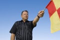 Linesman Showing Penalty Flag Against Blue Sky