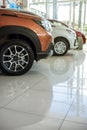 A lineup of unidentifiable cars on display inside a showroom or dealership. Concept of auto market business in Asia