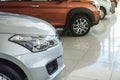 A lineup of unidentifiable cars on display inside a showroom or dealership. Concept of auto market business in Asia