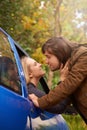 Lingering goodbyes. a young couple kissing each other goodbye through a car window.