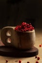 Lingonberries in a wooden Finnish mug on a dark background