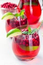 Lingonberry and lime punch or limeade in a glass and pitcher on gray background, vertical Royalty Free Stock Photo