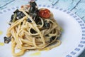 Linguine pasta with fresh anchovies, black cabbage and cherry tomatoes