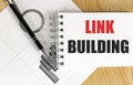 LINK BUILDING text on notebook with chart on wooden background Royalty Free Stock Photo