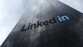 LinkedIn logo on a skyscraper facade reflecting clouds. Editorial 3D rendering