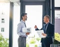 Linking their strategies to their core business aims. two businessmen having a discussion in an office.