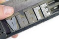 Linotype text in stick with hand spelling apple close