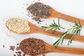 Linseed, chia and quinoa in wooden spoons.