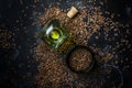 Linseed or flax oil in glass bottle and seeds, dark background,