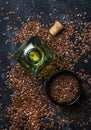 Linseed or flax oil in glass bottle and seeds, dark background,