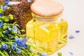 Linseed oil, flax seeds, and flowers on a light background. Royalty Free Stock Photo