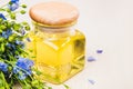 Linseed oil, flax seeds, and flowers on a light background. Royalty Free Stock Photo