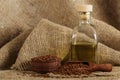 Linseed oil in a glass bottle and flax seeds on a wooden background