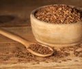 Linseed. Spoon and bowl of linseeds on wooden background Royalty Free Stock Photo