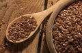 Linseed. Spoon and bowl of linseeds on wooden background. Top view. Royalty Free Stock Photo