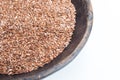 Linseeds in rustic wooden bowl isolated