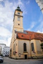 Linz, Austria, 27 August 2021: Medieval catholic Baroque Stadtpfarrkirche with tower, Parish Church at Pfarrplats, old town street Royalty Free Stock Photo