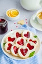 Linzer cookies with heart with raspberry jam and powdered sugar on a white plate with a cup of tea. Dessert on Valentine`s Day. Royalty Free Stock Photo