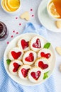 Linzer cookies with heart with raspberry jam and powdered sugar on a white plate with a cup of tea. Dessert on Valentine`s Day. Royalty Free Stock Photo