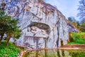 Lion of Lucerne stone monument carved in a rocky cliff with small memorial pond in a park of Lucerne, Switzerland Royalty Free Stock Photo