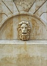 A lion's head on the wall of the old fountain