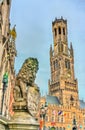 Lion Statue and the Belfry of Bruges, a medieval bell tower in Belgium Royalty Free Stock Photo