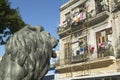 Lion statue looking at old buildings with laundry in Old Havana, Cuba