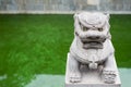 Lion stone statue with a green pond in the background Royalty Free Stock Photo