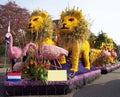 Lions and flamingo made from flowers. Car decorated with flowers, flower parade.