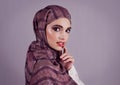 Lips as red as a good wine. Studio portrait of a confident young woman wearing a colorful head scarf while applying red Royalty Free Stock Photo