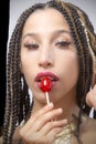 Lips of beautiful young Latina touching a red candy pop Royalty Free Stock Photo