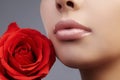 Lips with bright lipgloss makeup. Perfect clean skin, fresh lip make-up. Beautiful spa with tender pink rose flower Royalty Free Stock Photo