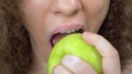 Lips close up. beautiful woman bites a juicy green apple