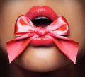 Lips, closeup and ribbon of female person, lick and beauty and makeup on white background. Lipstick, cosmetics and mouth