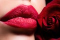 Lips with lipstick closeup. Beauty Red Lips Makeup Detail. Beautiful woman lips with rose. Royalty Free Stock Photo