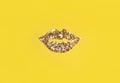 Lips from little golden confetti on a yellow background. Modern style. Trend. Top view.