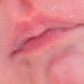 Lips in milk on the face of a newborn baby, close-up. Macro photo of a healthy child mouth after feeding Royalty Free Stock Photo