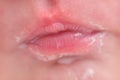 Lips in milk on the face of a newborn baby, close-up. Macro photo of a healthy child mouth after feeding Royalty Free Stock Photo