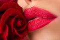 Lips with red lipstick closeup. Beautiful woman lips with rose. Perfect clean skin, sexy lip make-up. Beautiful spa Royalty Free Stock Photo