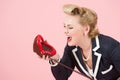 Lips and shout. Blonde pin up styled woman shout to telephone. Lady expression over the phone. Girl on rose background Royalty Free Stock Photo