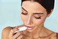 Lips Skin Care. Beautiful Woman Applies Lipbalm Protection On