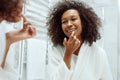 Lips skin care. Woman applying lip balm in bathroom portrait Royalty Free Stock Photo